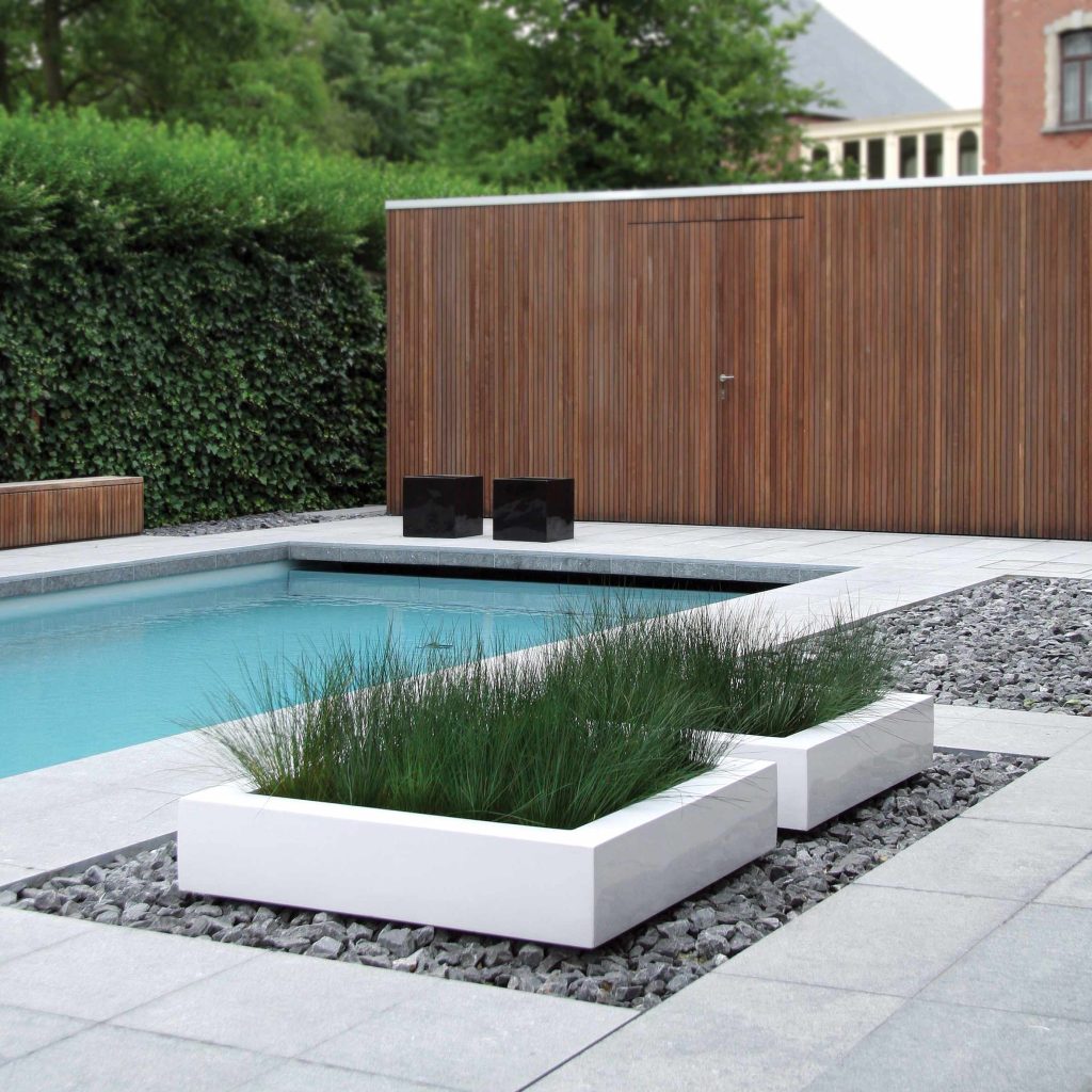 Example of a minimalist concrete paver and rectangular pool design in Other