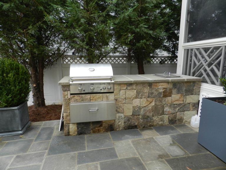 Example of a small 1950s backyard stone patio kitchen design in Raleigh with no cover