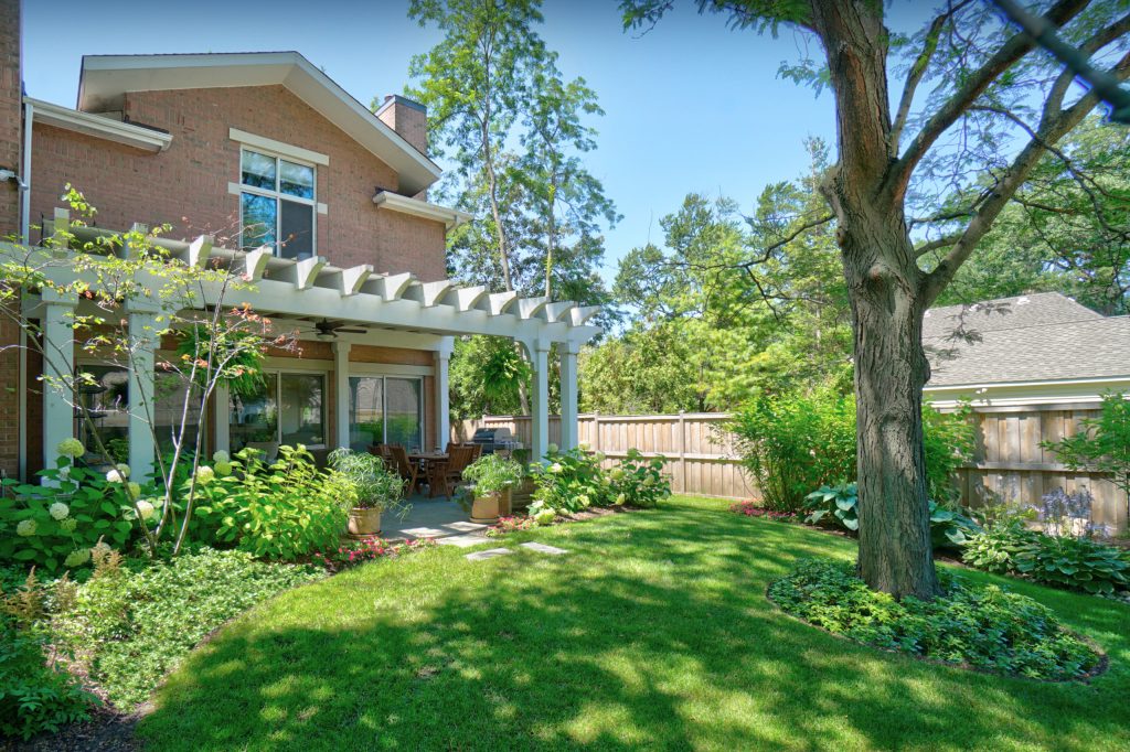 Example of a small classic backyard stone patio kitchen design in Chicago with a pergola
