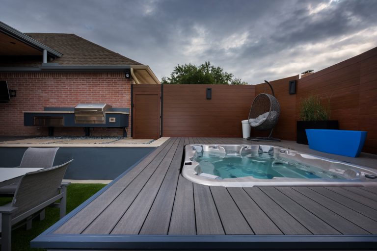 Example of a small minimalist backyard concrete paver patio kitchen design in Dallas with a roof extension
