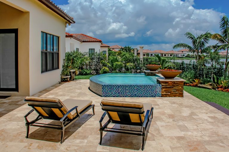 Example of a small minimalist backyard stone and custom-shaped aboveground hot tub design in Miami