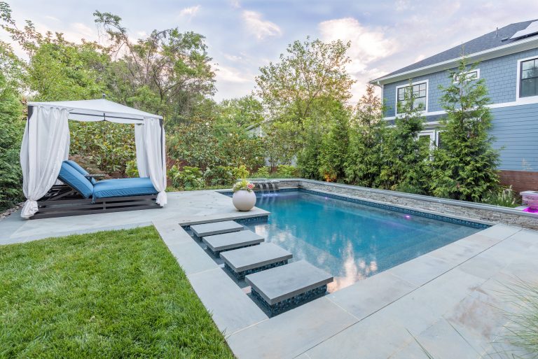 Example of a small minimalist backyard stone and rectangular pool fountain design in DC Metro