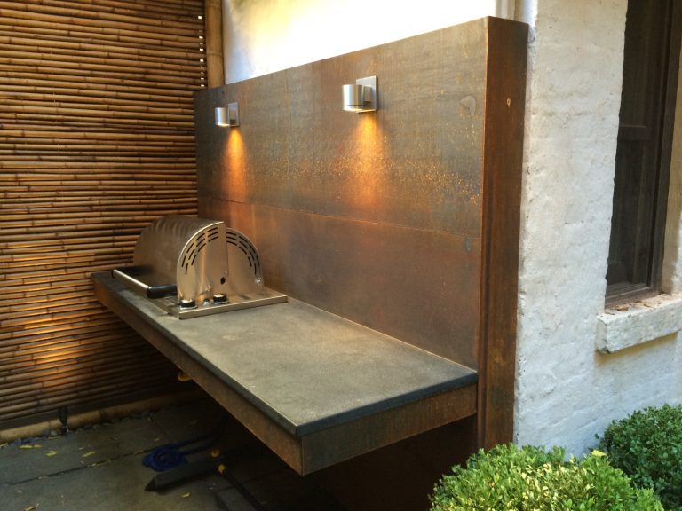 Example of a small minimalist backyard stone patio kitchen design in New York with no cover