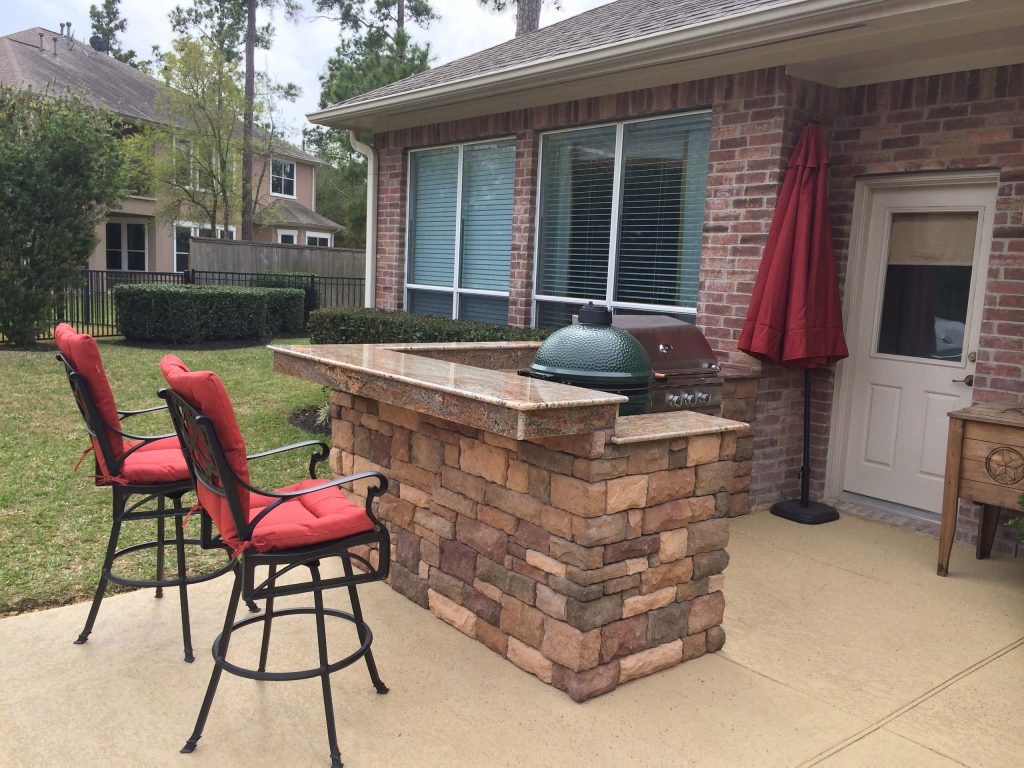 Example of a small transitional backyard stamped concrete patio kitchen design in Houston