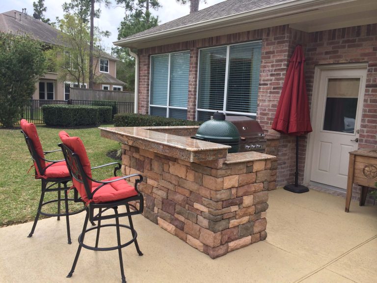 Example of a small transitional backyard stamped concrete patio kitchen design in Houston