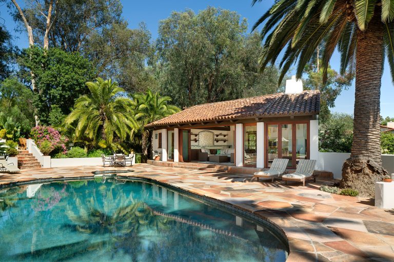 Example of a southwest backyard stone and round natural pool house design in San Diego