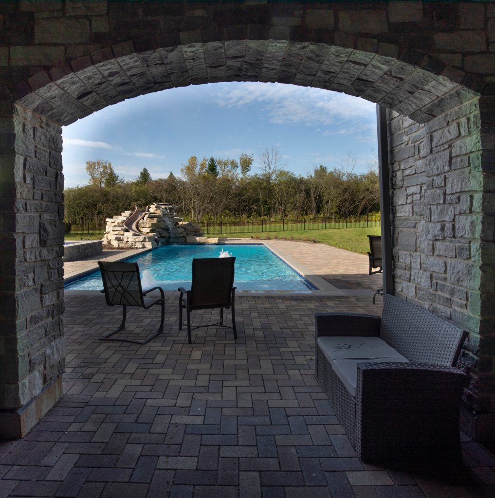 Example of a transitional backyard brick and rectangular lap pool landscaping design in Chicago