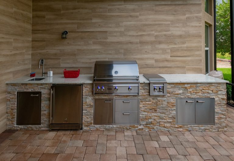 Example of a transitional backyard brick patio kitchen design in Miami with an awning