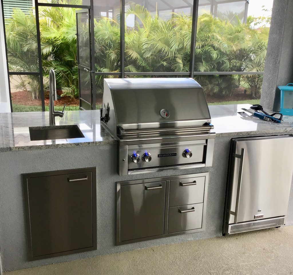 Example of a transitional backyard concrete patio kitchen design in Miami with a roof extension