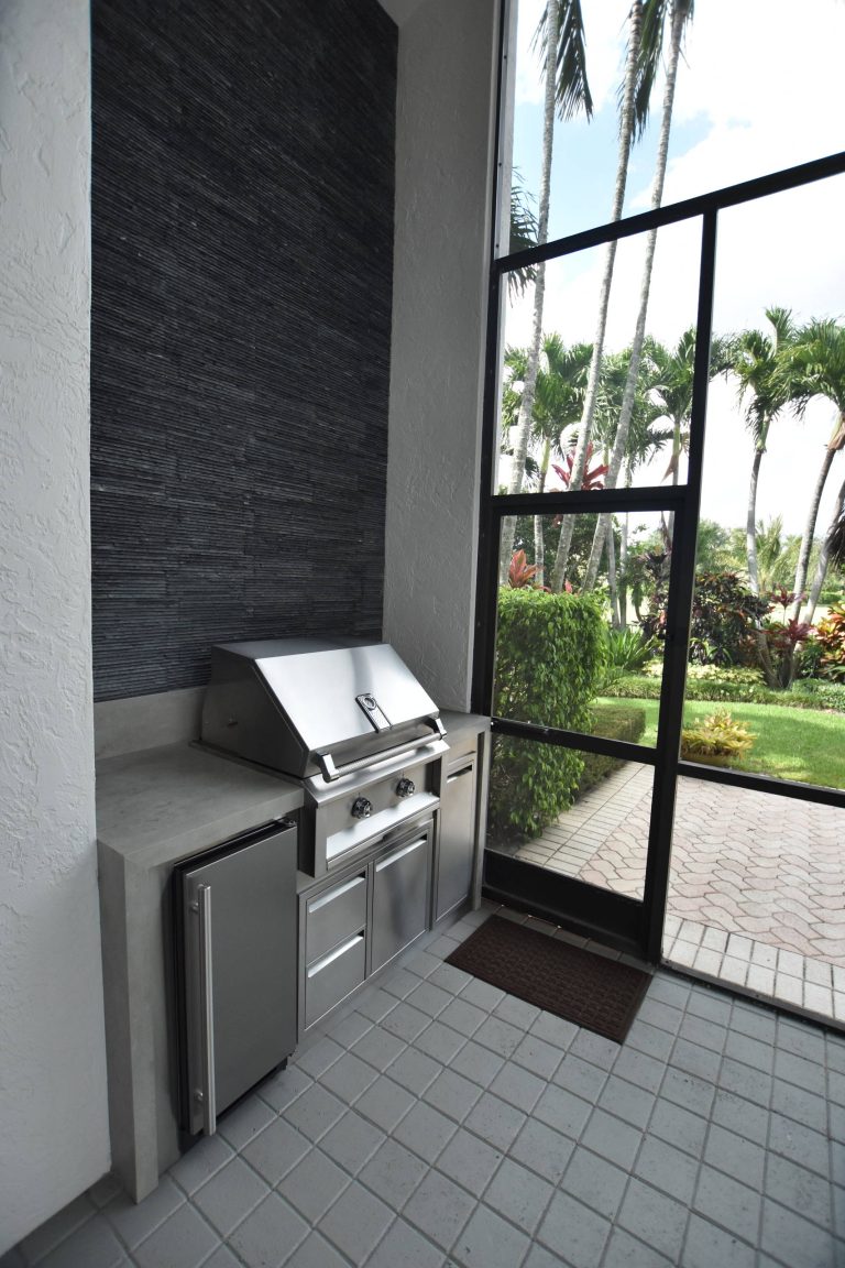 Example of a transitional backyard concrete paver patio kitchen design in Miami with a roof extension