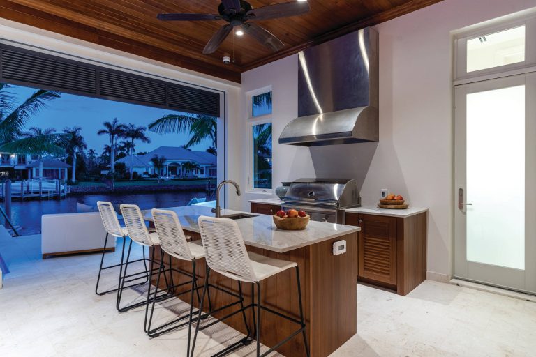 Example of a transitional backyard patio kitchen design in Miami with a roof extension