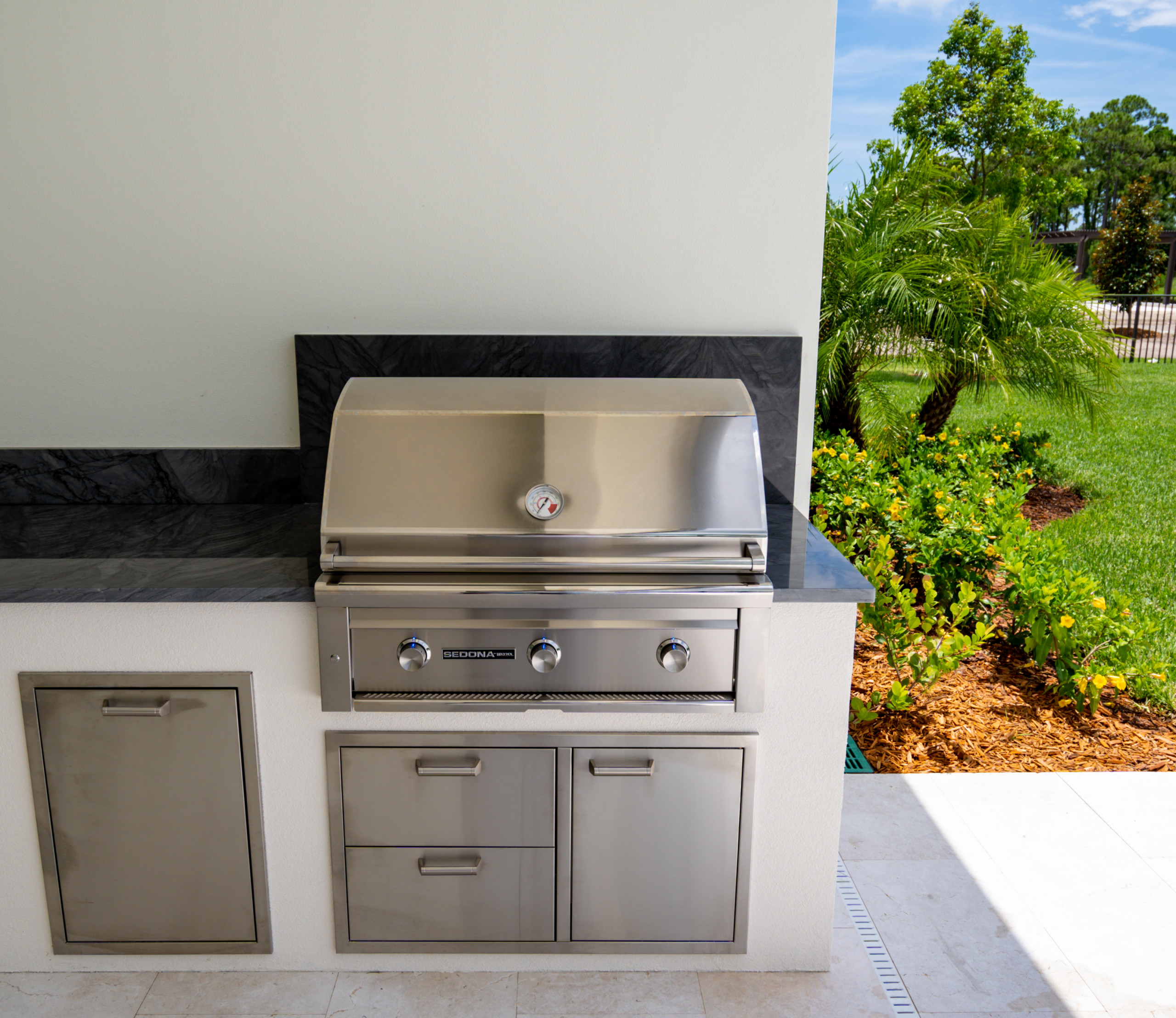 Example of a transitional backyard stone patio kitchen design in Miami with a roof extension