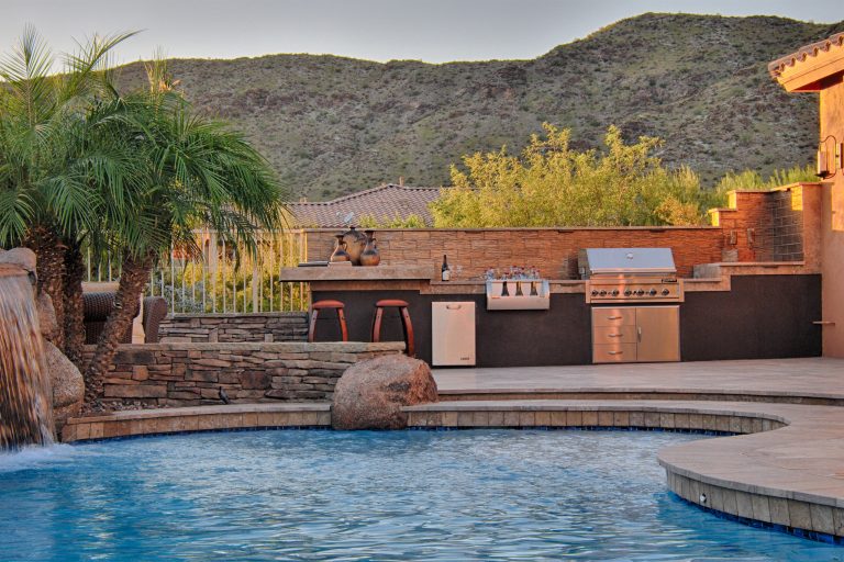 Example of a transitional backyard stone patio kitchen design in Phoenix