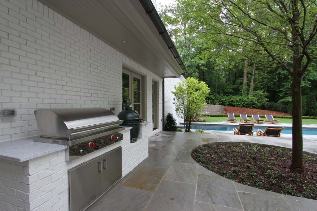 Example of a transitional stone patio kitchen design in Atlanta with no cover