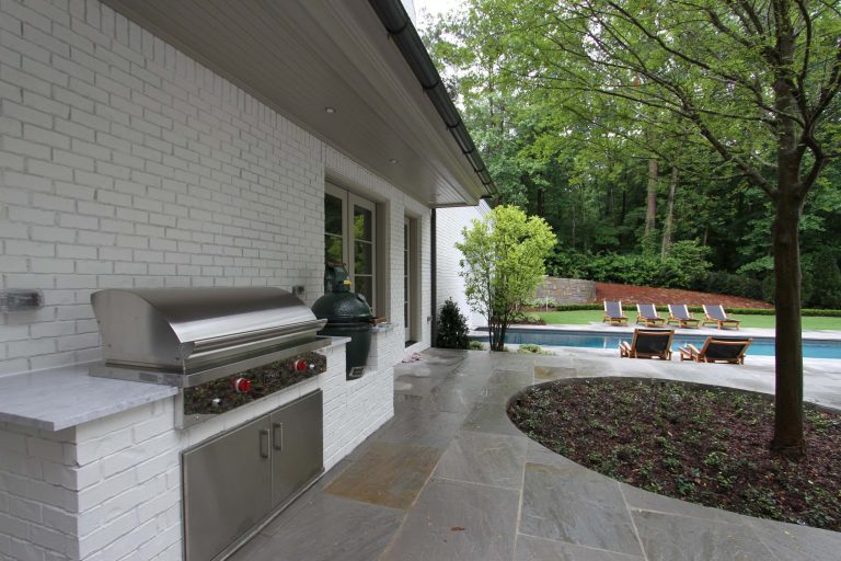 Example of a transitional stone patio kitchen design in Atlanta with no cover
