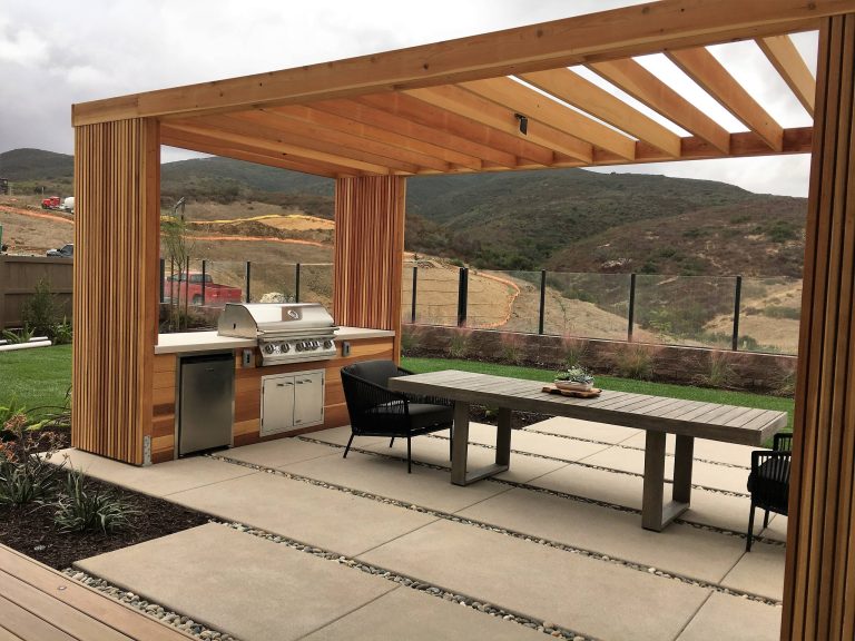 Example of a trendy backyard concrete patio kitchen design in San Diego with a pergola