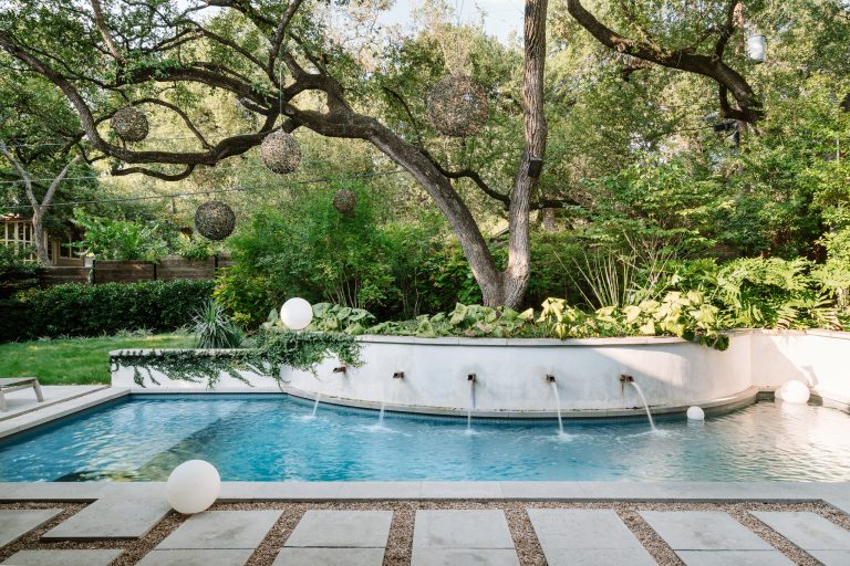 Example of a trendy backyard concrete paver and custom-shaped pool fountain design in Austin