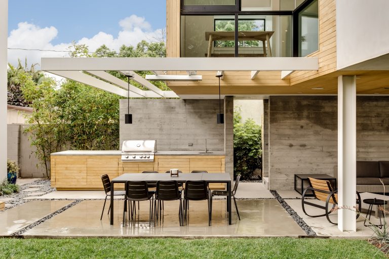 Example of a trendy concrete patio kitchen design in Los Angeles with a roof extension