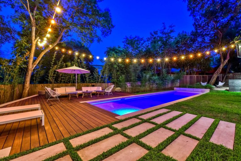 Example of a trendy rectangular pool design in Austin with decking