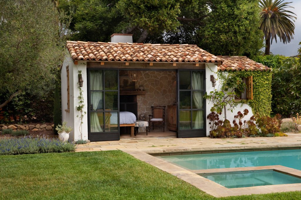 Example of a tuscan stone and rectangular lap pool house design in Santa Barbara