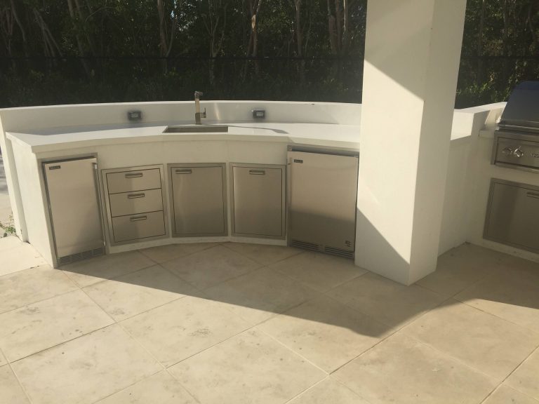 Example of an island style backyard stone patio kitchen design in Miami with a roof extension