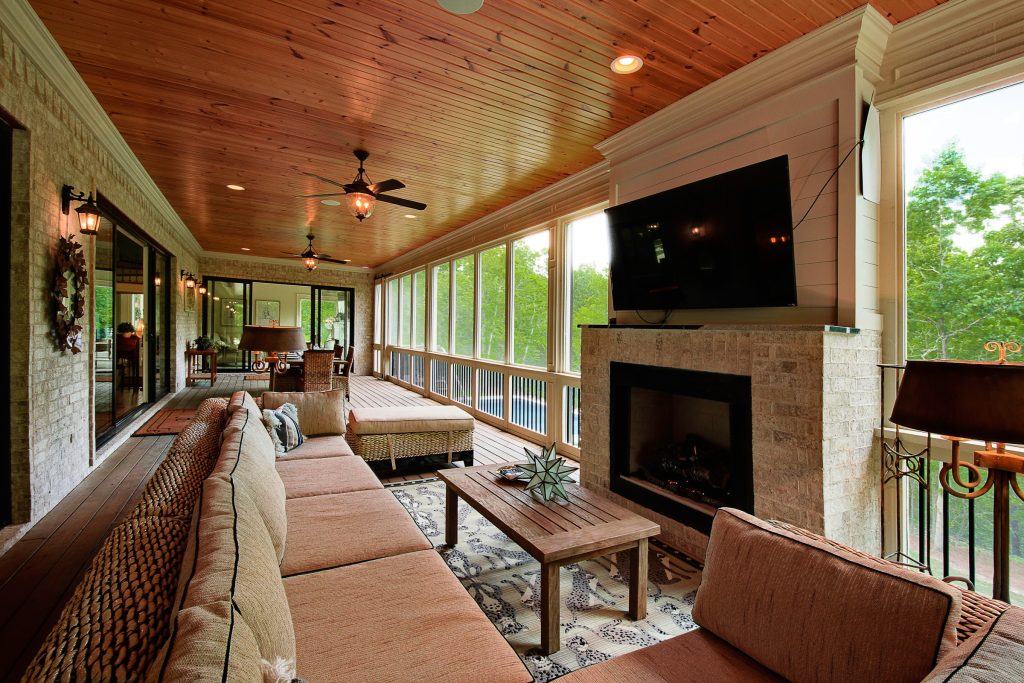 Expansive screened in porch with fireplace, TV, and dining area