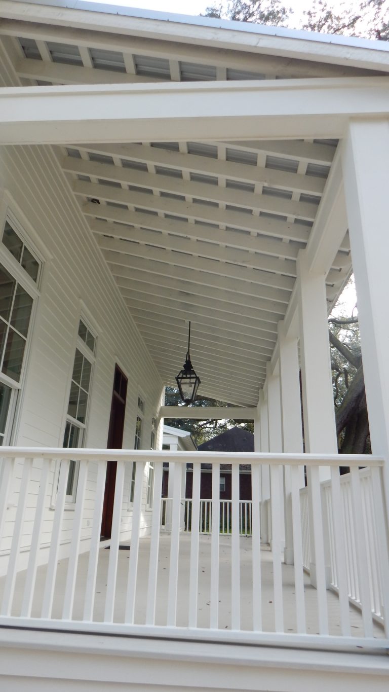 Exposed rafters give the screened in porch an ageless look. Photo by Tom Aiken