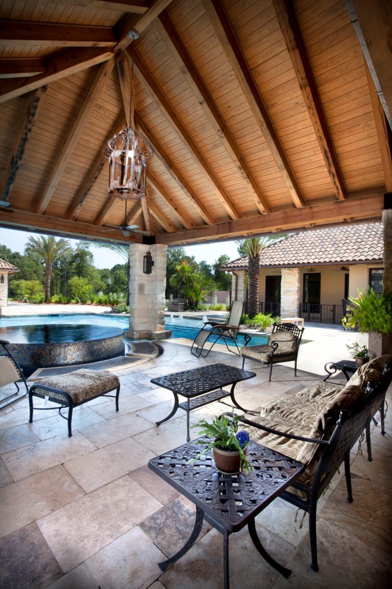 Exposed reclaimed beams and reclaimed wood ceiling create a pool side oasis in this home.