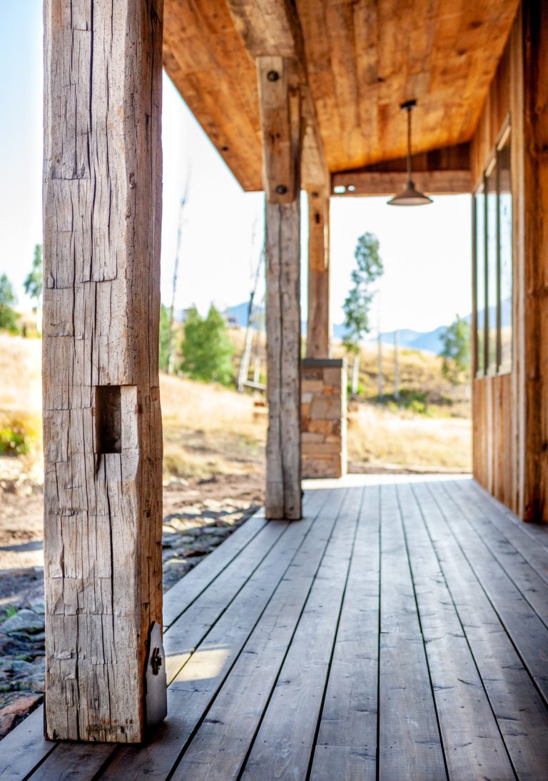 Exterior hand hewn porch posts with custom metal bracket.
