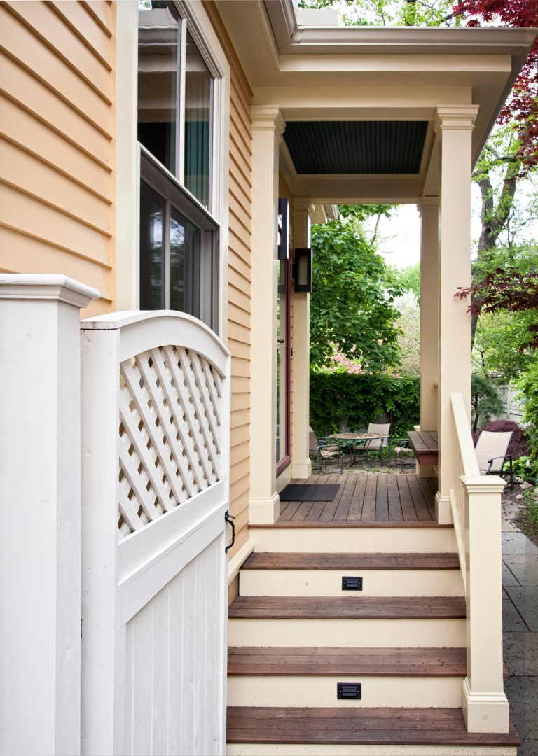 Exterior side porch with dual stair access from driveway entryway and to back patio covered with natural stone pavers. design: Marta Kruszelnicka photo: Todd Gieg by Don Foote Contracting | Outdoor Photos | Porch | Landscaping | Landscape Design | Outdoor Living Space | Porch Design Ideas | Outdoor Living Space Ideas | Backyard Design