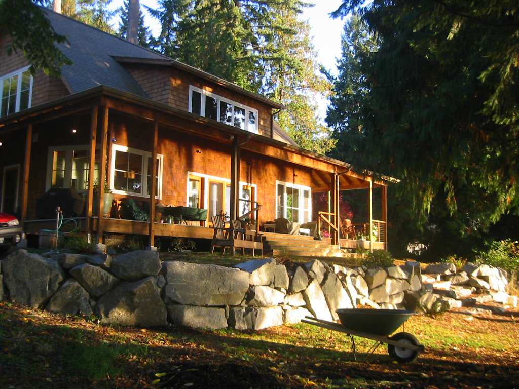 Facing a lake view and paralleling the interior great room, the deck provides an active living space in the summer and sheltered outdoor room in the rainy Seattle winter. by James Hill Architect, AIA | Outdoor Photos | Porch | Landscaping | Landscape Design | Outdoor Living Space | Porch Design Ideas | Outdoor Living Space Ideas | Backyard Design