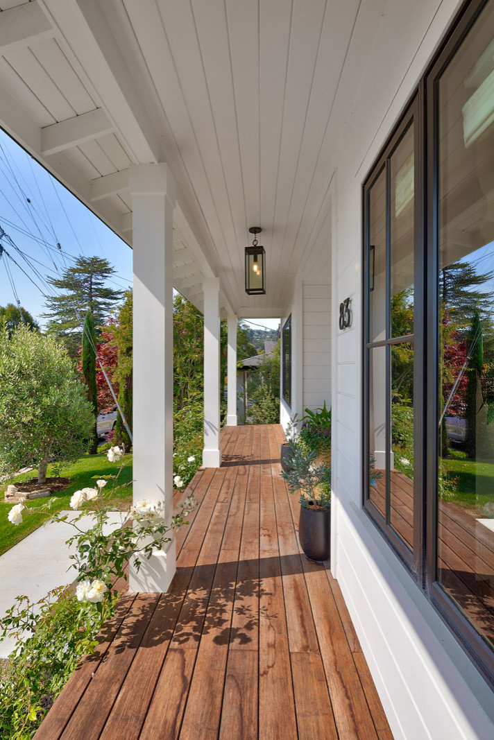 Farmhouse Modern home with horizontal and batten and board white siding and gray/black raised seam metal roofing and black windows.