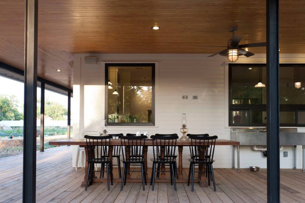 Farmhouse porch photo in Austin with decking by Risinger Homes | Outdoor Photos | Porch | Landscaping | Landscape Design | Outdoor Living Space | Porch Design Ideas | Outdoor Living Space Ideas | Backyard Design