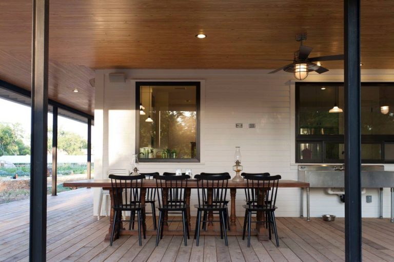 Farmhouse porch photo in Austin with decking by Risinger Homes | Outdoor Photos | Porch | Landscaping | Landscape Design | Outdoor Living Space | Porch Design Ideas | Outdoor Living Space Ideas | Backyard Design