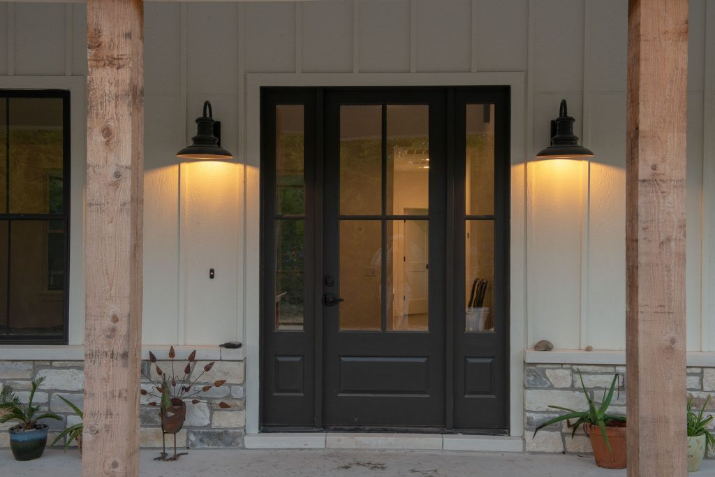 Farmhouse-style sconces frame the front entry door. Photography: Wayne C. Jeansonne