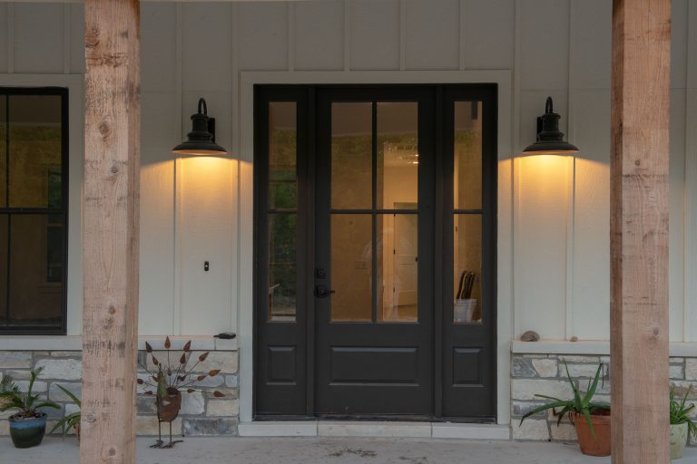 Farmhouse-style sconces frame the front entry door. Photography: Wayne C. Jeansonne
