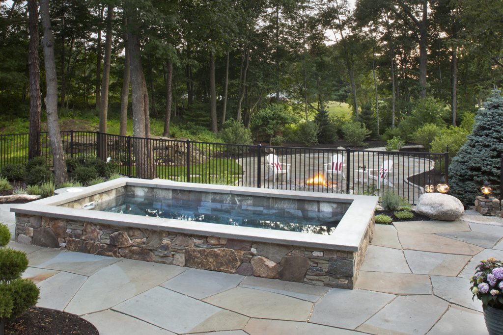 Finished project, Soake Pool surrounded by lovely stone work and bluestone patio overlooking gas fire pit area. A truly stunning backyard retreat! Photo Credit: Tim Murphy, Foto Imagery by Soake Pools | Pool design | Pool Contracting | Swimming Pool Ideas | Swimming Pool Design Ideas