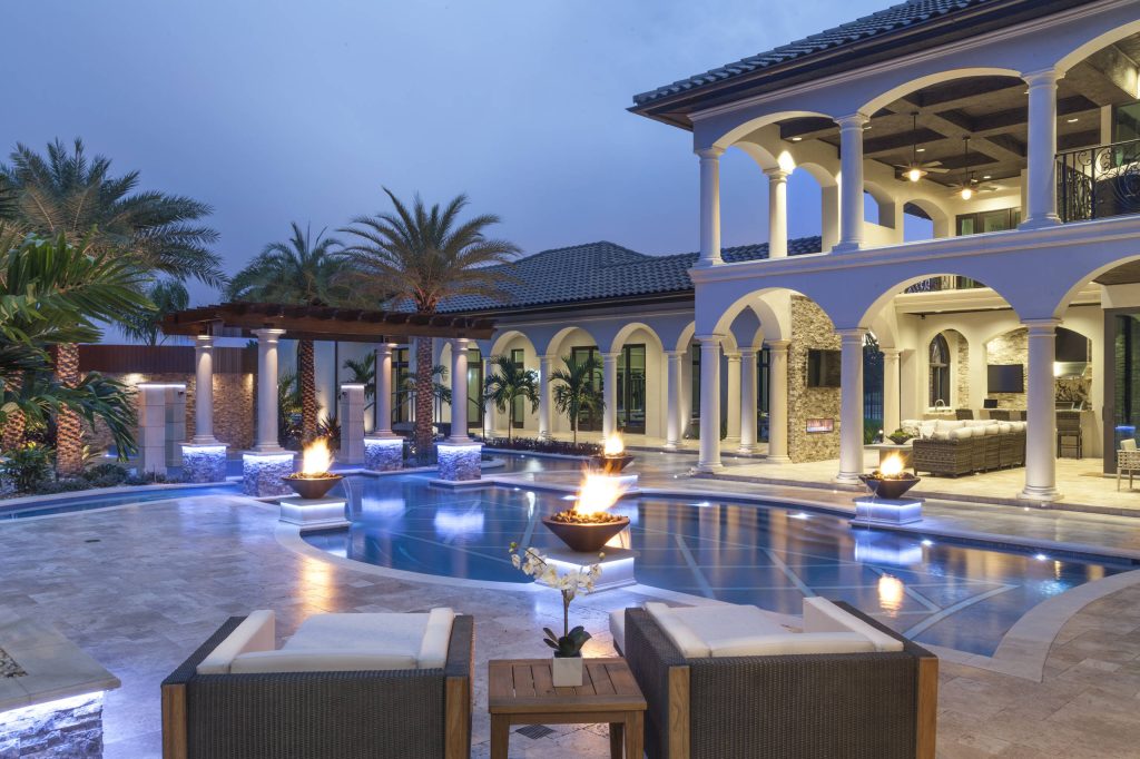 Fire pots from Grand Effects are positioned adjacent to the steps into the pool. The glow creates a relaxed ambiance for quiet moments enjoyed in the outdoor space.