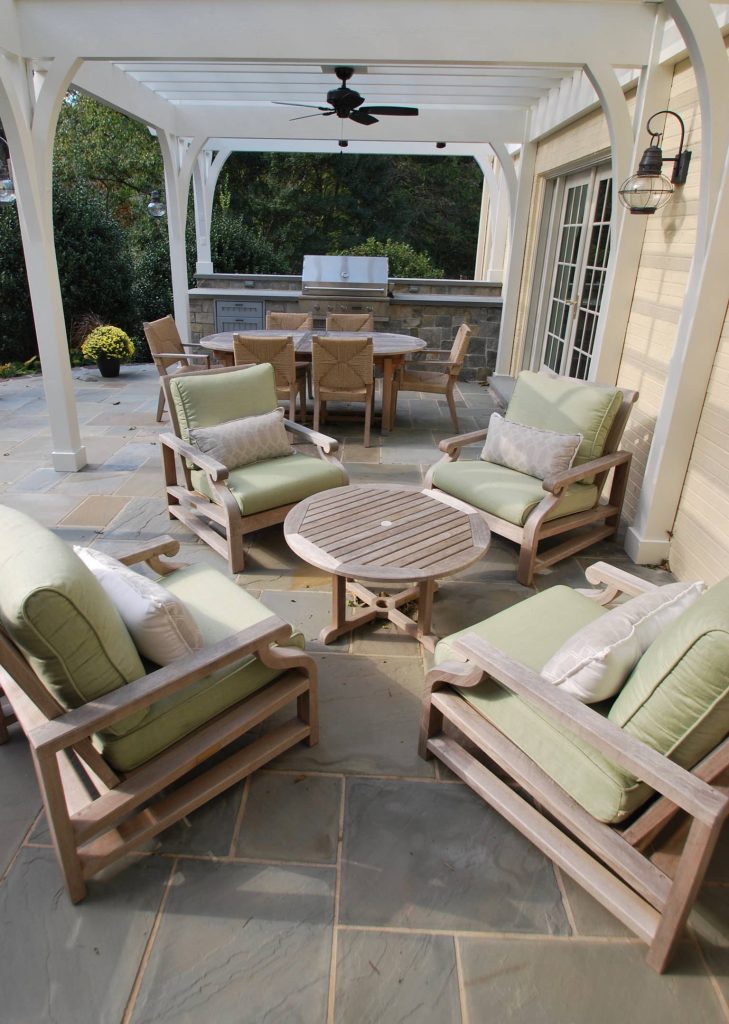Four chair teak deep seating conversation area. Expandable teak dining set with all weather rope woven dining chairs. Stone built in grill. All under a shading pergola. by Michael Molesky Interior Design | Outdoor Kitchens | Backyard Design | Outdoor Living Spaces | Landscape Design