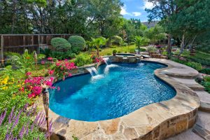 Freeform pool with sheer descents and a raised spa with spillways.
