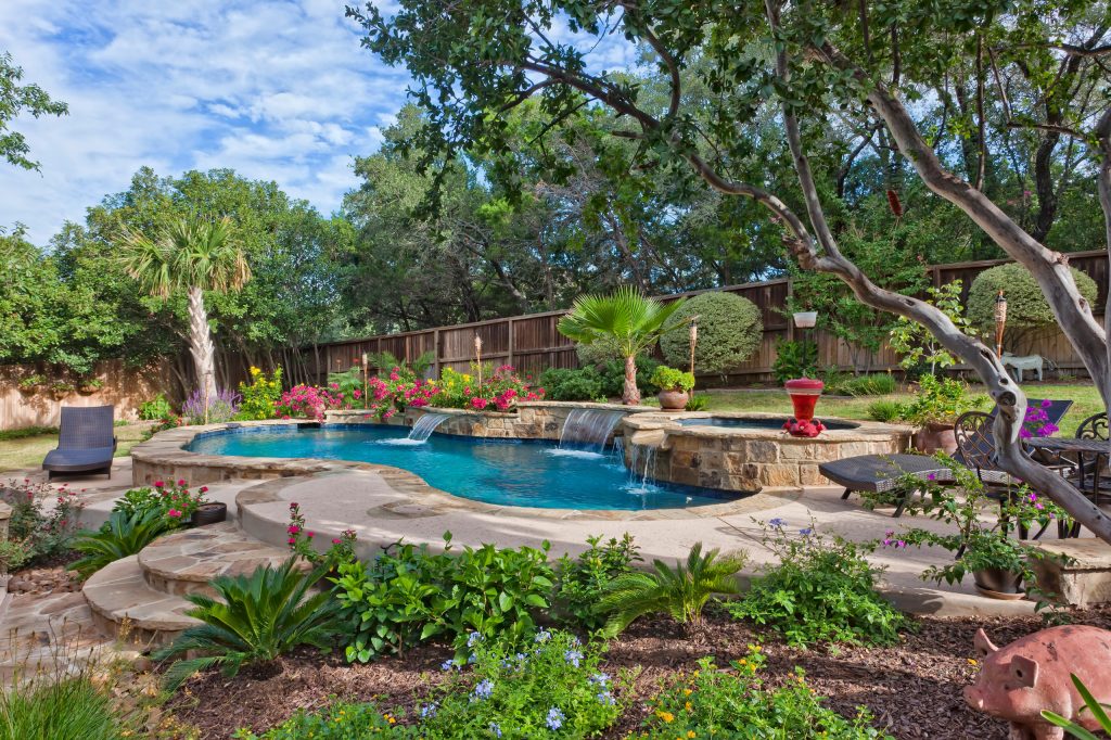 Freeform pool with sheer descents and a raised spa with spillways.