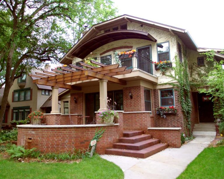 Front addition with curved patio, trellis and second floor balcony. Metal “eyebrow” overhang was designed to match existing brick detailing.