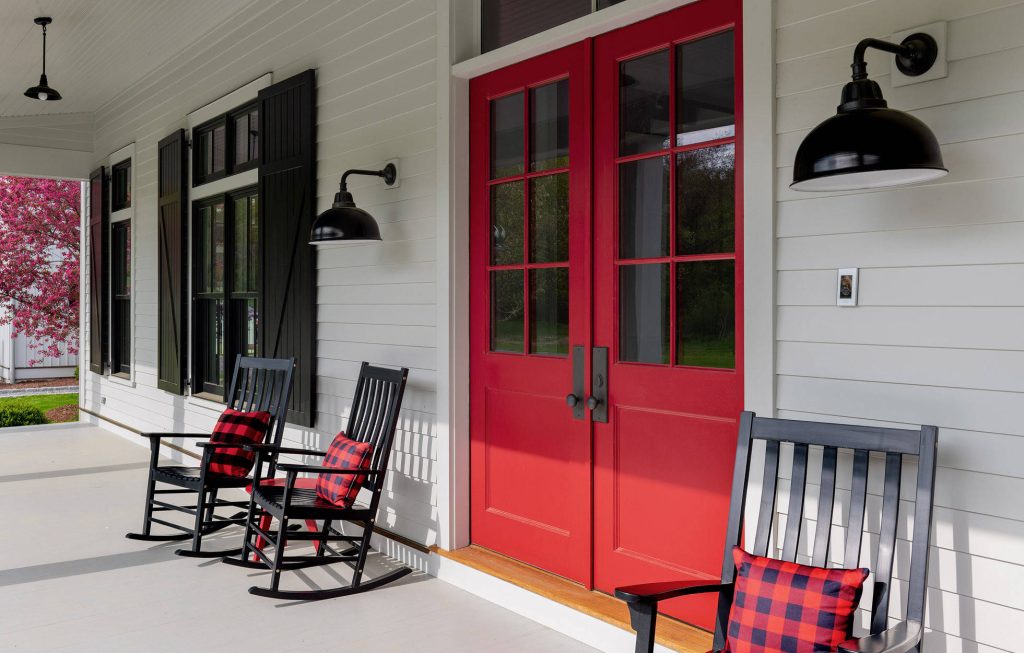 Front porch with rocking chairs and a red door. Photographer: Rob Karosis