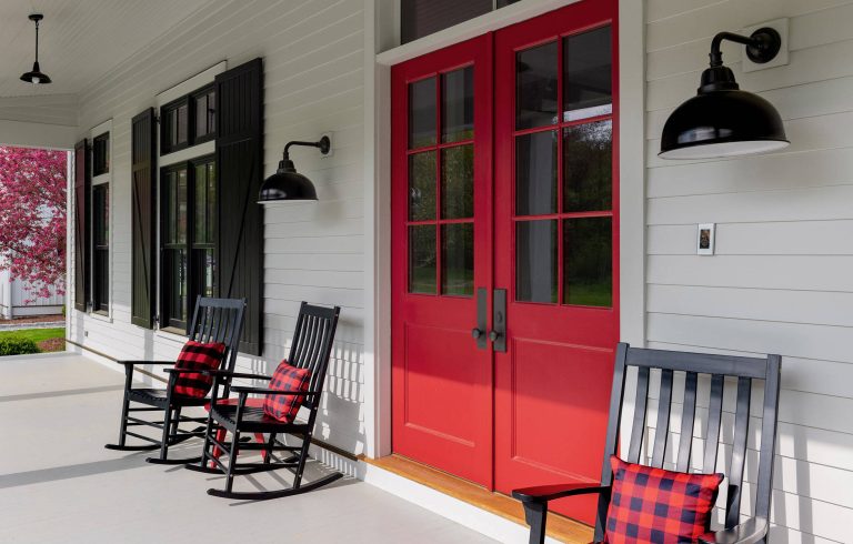 Front porch with rocking chairs and a red door. Photographer: Rob Karosis