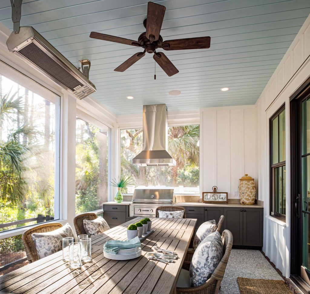 Gas porch heater, ceiling fan, tongue and groove ceiling, built-in grill with vent hood, outdoor kitchen, and tabby floor.