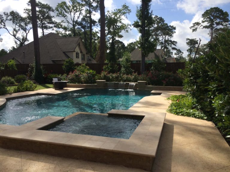 Geometric travertine pool with raised spa and raised beam water feature wall. Satin Matrix pebble interior and rock salt decking.