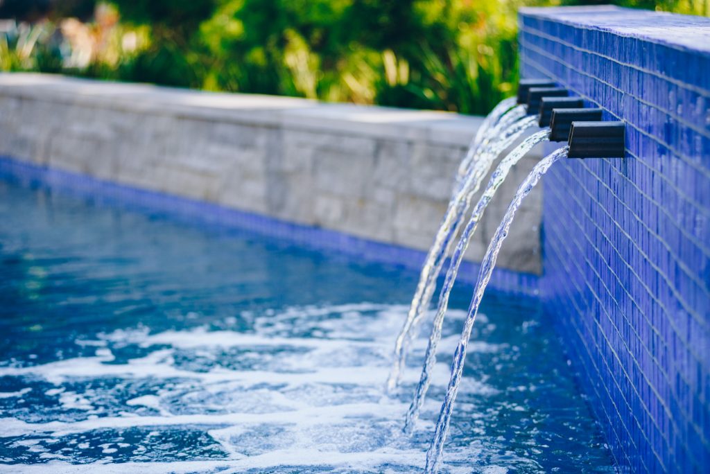 Glass tile from Lightstreams and custom stainless steel spouts make this a great water feature and accent to the garden.