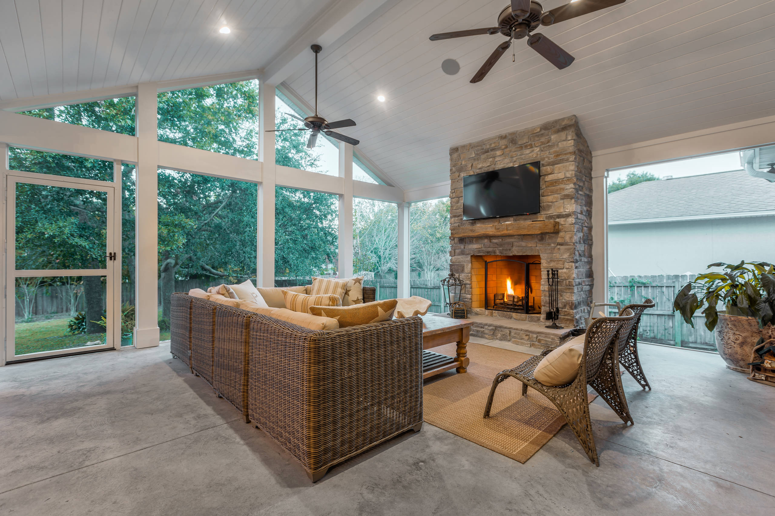 Greg Riegler
Large transitional concrete screened-in back porch idea in Other with a roof extension