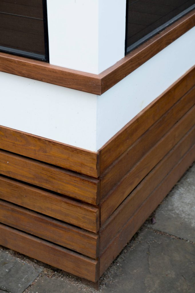 Horizontal under-deck trim - stained hardwood. Using the hardwood in tandem with the Zuri decking provides an illusion in-person that the Zuri boards are real wood. Photo: Michael Ventura. by Design Builders, Inc. | Outdoor Photos | Porch | Landscaping | Landscape Design | Outdoor Living Space | Porch Design Ideas | Outdoor Living Space Ideas | Backyard Design