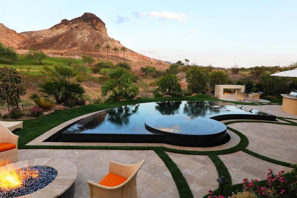Hot tub - contemporary backyard stone and custom-shaped infinity hot tub idea in Las Vegas